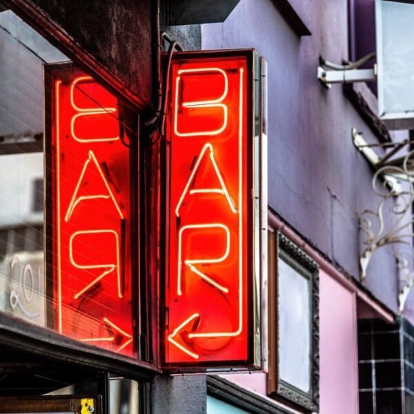 A red neon sign featuring the word BAR and a arrow pointing to the left